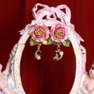 A pair of earrings hanging from the side of a picture frame.