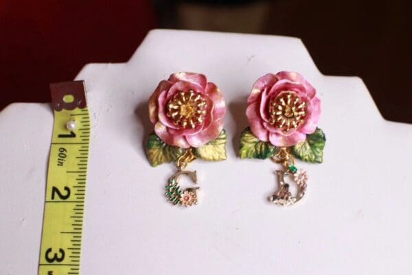 A pair of earrings with flowers and initials.