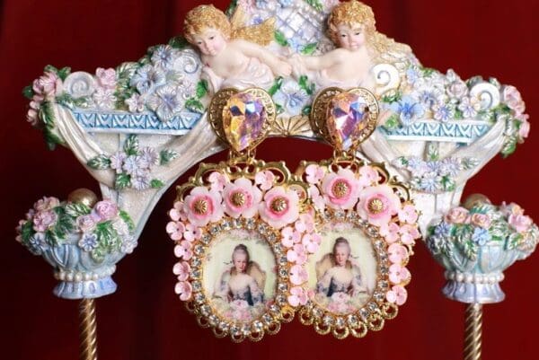 A pair of earrings with pictures on them hanging from the side of a wall.