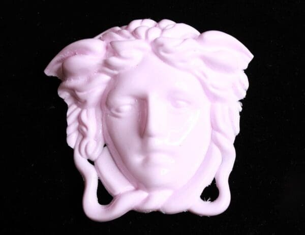 A white statue of medusa head with long hair.