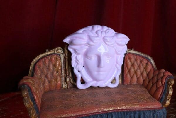 A white mask sitting on top of a wooden chair.