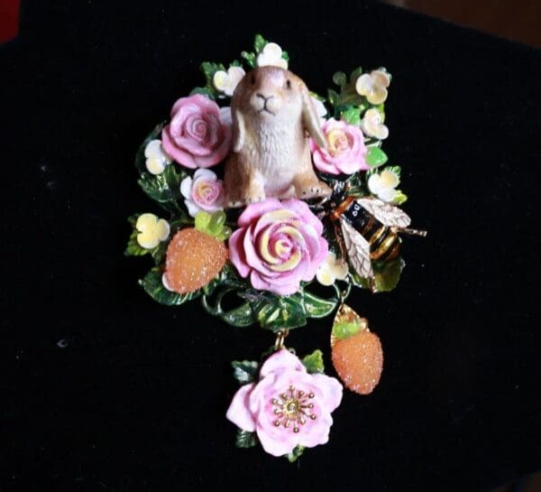A cat figurine sitting on top of flowers.