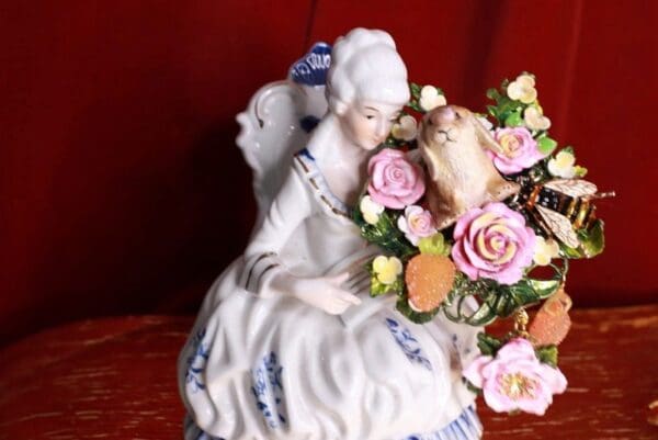 A porcelain figurine of a woman and cat.