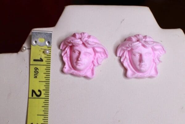 A pair of pink earrings sitting on top of a table.