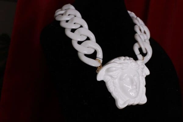 A white necklace with a face on it