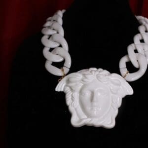 A white necklace with a face on it.