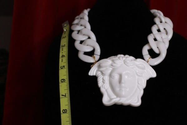 A white necklace with a face on it