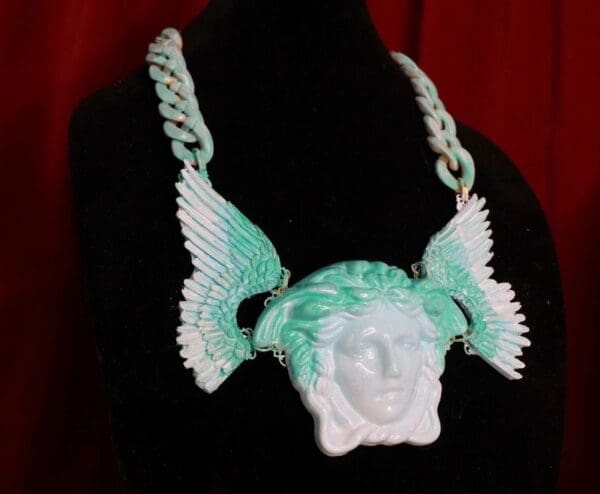 A necklace with an angel head and wings.