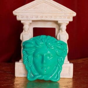 A statue of a face with a green head.
