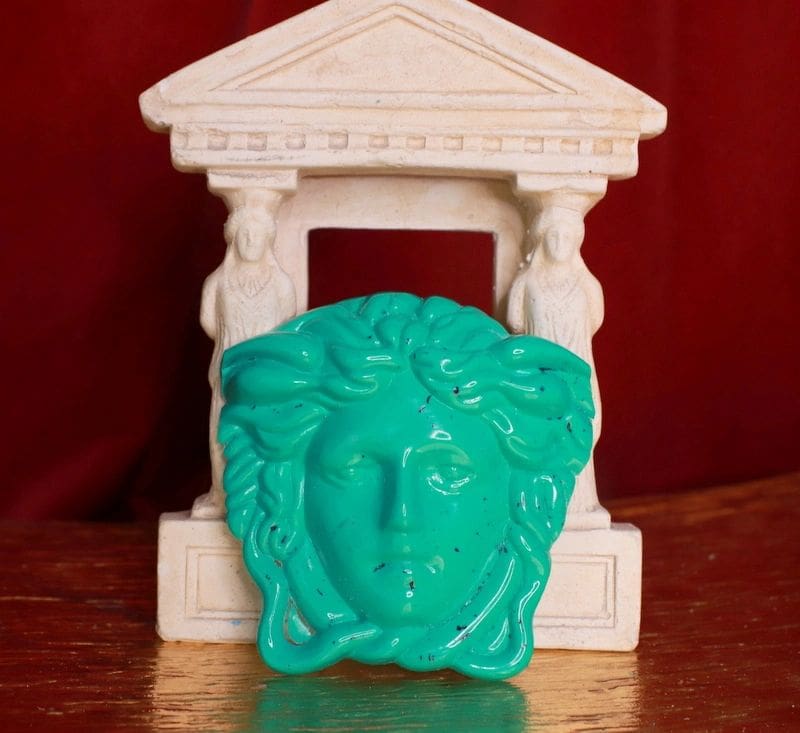A statue of a face with a green head.