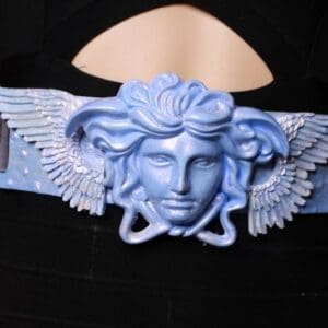 A blue winged medusa head on the side of a black hat.