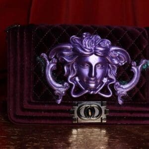 A purple purse with a face on it