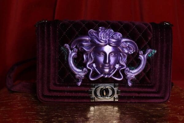 A purple purse with a face on it