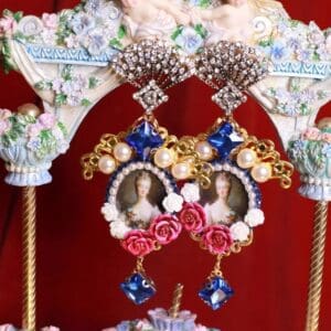 A pair of earrings with pearls and flowers on them.
