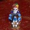 A small skull with blue and yellow beads on it.