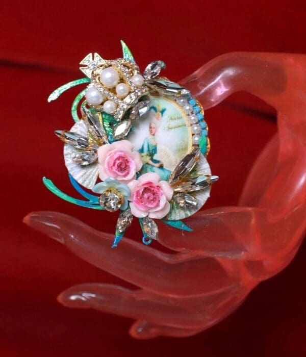 A hand holding a small decorative object with flowers.