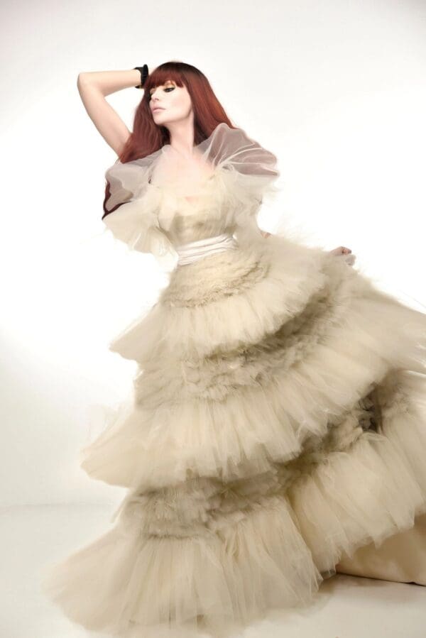 A woman in a white dress is posing for the camera.