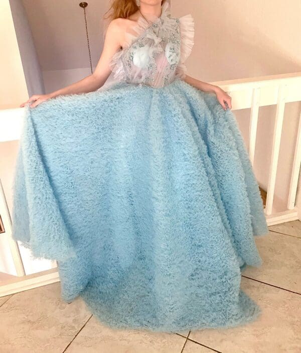 A woman in a blue dress posing for the camera.