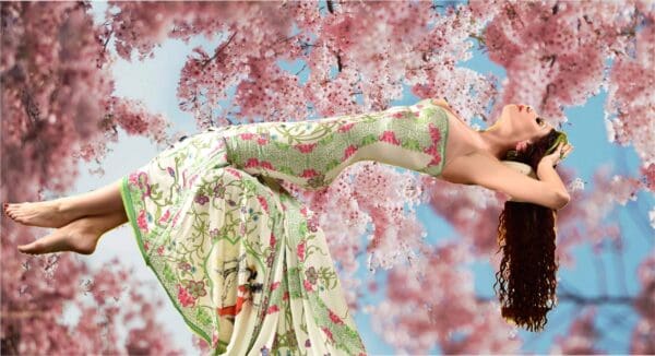 A woman in floral dress and pink flowers.