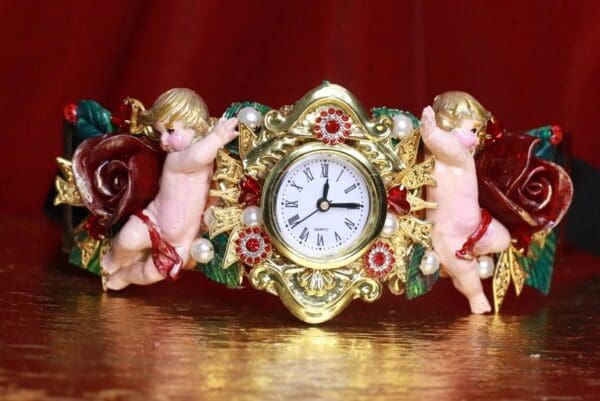 A clock with two angels on it sitting on the floor.