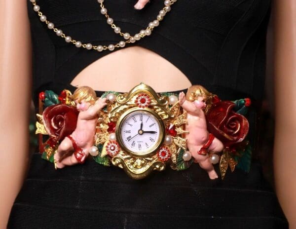 A clock with two angels and roses on it.