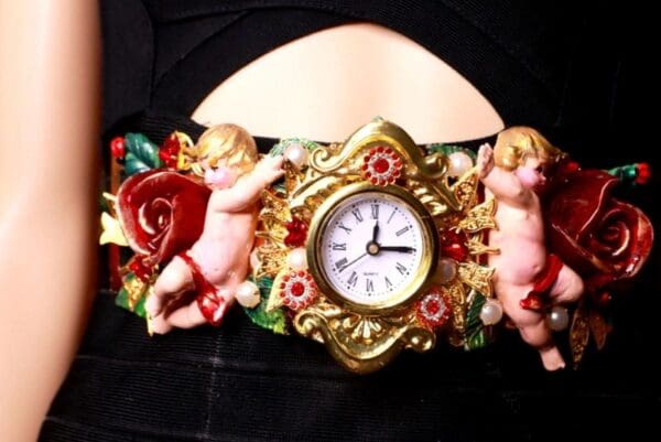 A woman wearing a belt with angels and a clock.