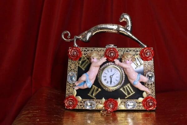 A clock with two angels on it sitting on top of a table.