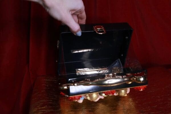 A person is opening up an open briefcase.
