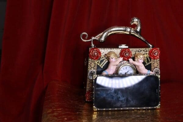 A purse with two angels on it sitting on top of a table.