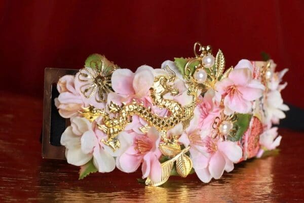 A close up of a pink flower with gold flowers