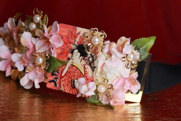 A wooden table with flowers and pearls on it.