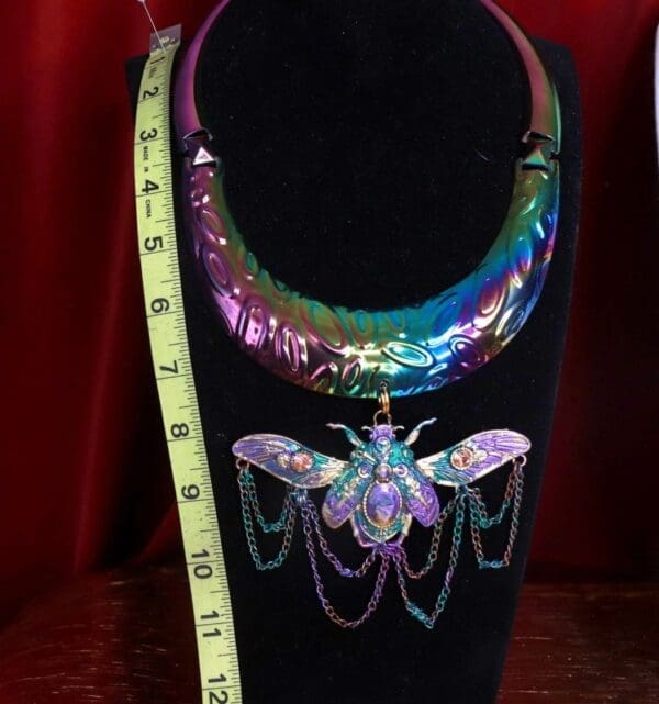 A necklace that is on display in front of a measuring tape.