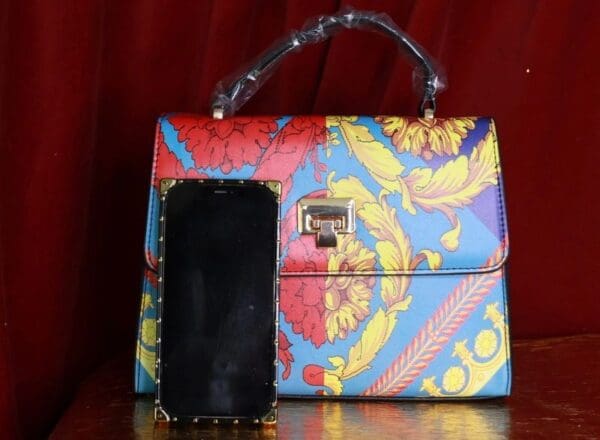 A purse and cell phone sitting on top of a table.