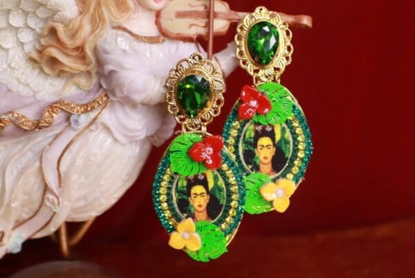 A pair of earrings with a picture of frida kahlo.