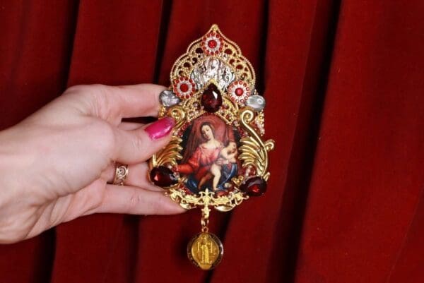 A woman holding onto a small painting of jesus