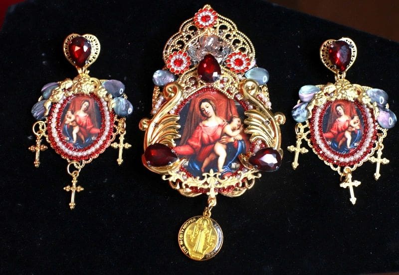 A set of three religious jewelry with red and gold accents.