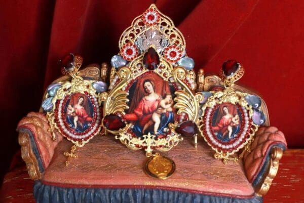 A crown with pictures of jesus and angels on it.