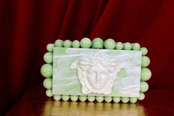 A green and white picture frame with a face on it.