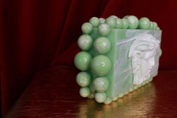 A green soap with white bubbles on top of it.