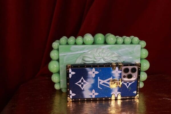 A green bracelet with a blue and white lv bag on it