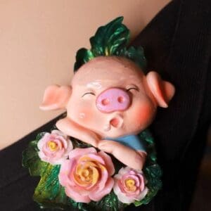 A pig figurine with pink flowers on it.