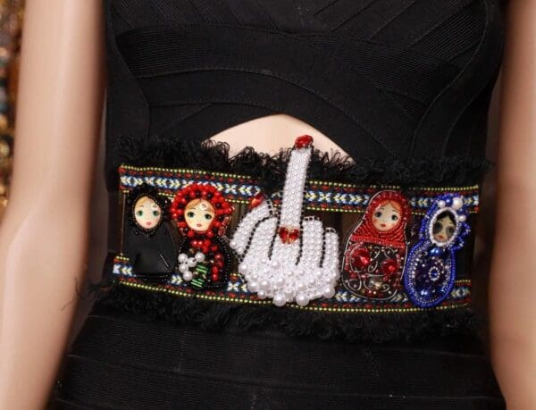 A close up of the waist band of a woman wearing a black dress