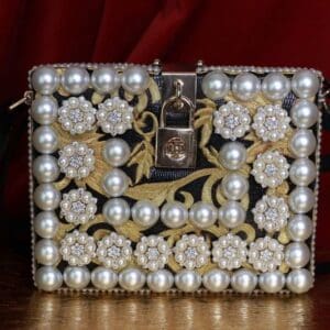 A purse with pearls and flowers on it.