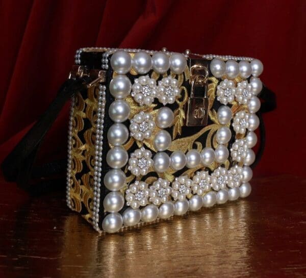 A purse that is made of pearls and gold.