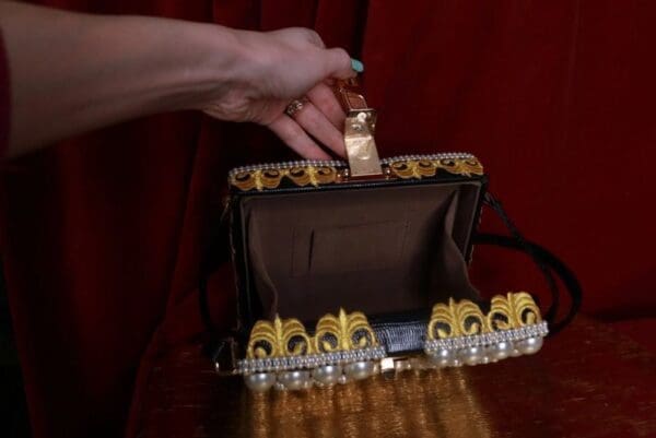 A woman opening up her purse to reveal the inside.