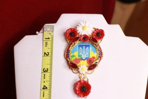 A white table with a red and yellow flower decorated item.