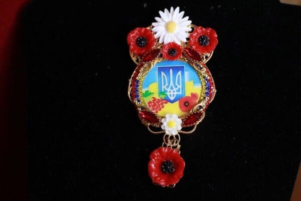 A brooch with flowers and a ukrainian flag.