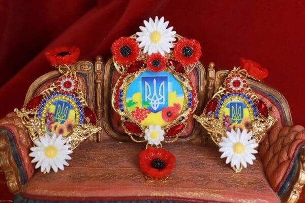 A wooden table with three decorated crowns on it.