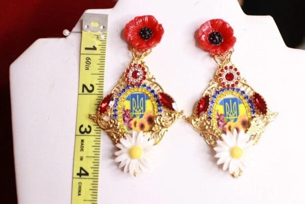 A pair of earrings with flowers and a ruler