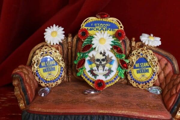 A table with two chairs and three decorated eggs.